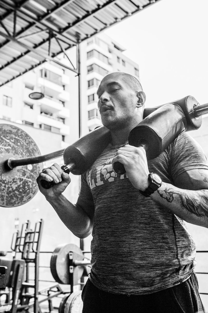 Alumno de Fit4Life haciendo sentadilla con la barra de seguridad