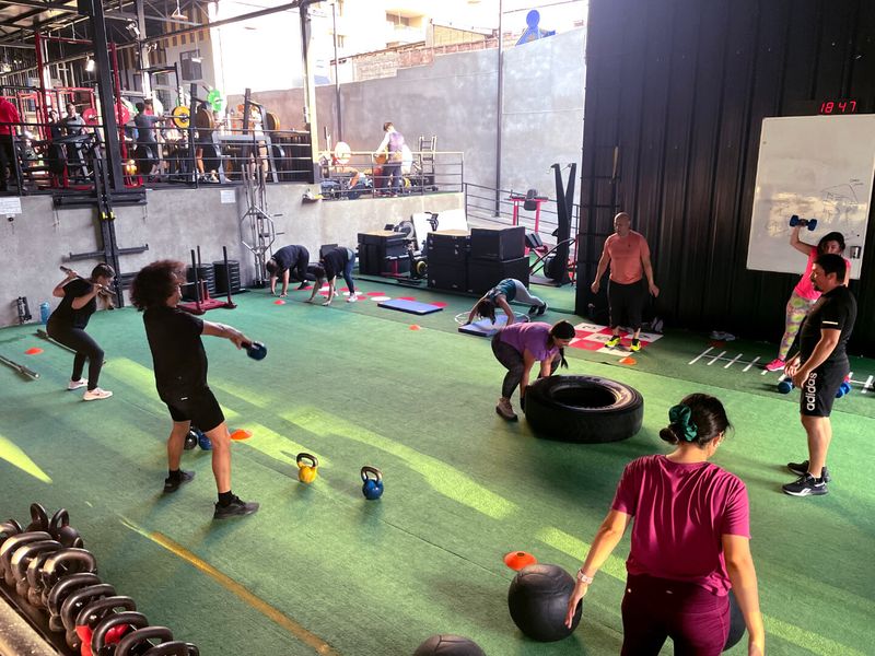 Clase dirigida grupal sobre el pasto del gimnasio