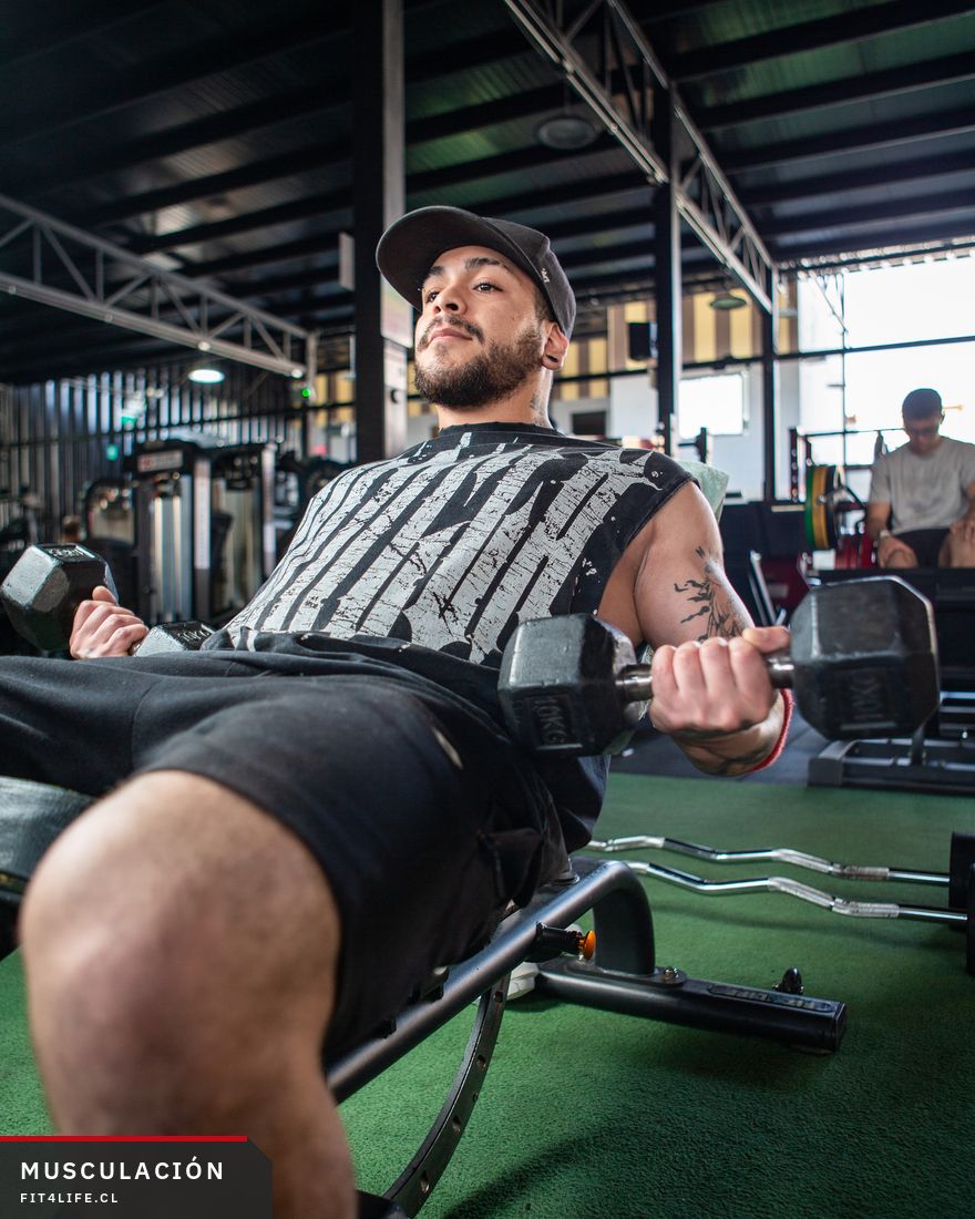 Alumno haciendo press con mancuernas en el centro Fit4Life